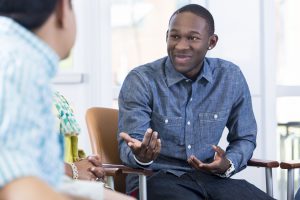 Young man explaining something in a group therapy.
