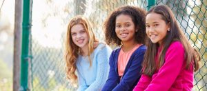 Three Young Girls Hanging Out Together In Park