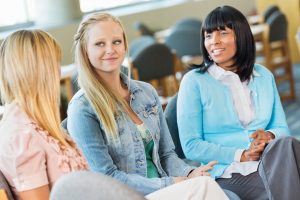 Two teenage girls in group therapy with a counselor